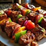 Close-up of Delicious Memorial Day Steak Kabobs with grilled steak, bell peppers, onions, and tomatoes.