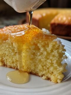 Close-up of a slice of cornbread being drizzled with Irresistible Hot Honey Recipe for sweet and spicy dishes.