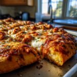 Close-up of a slice of Irresistible BBQ Chicken Pizza, with melted cheese and chicken pieces.