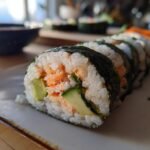 Close-up of a freshly made California Roll sushi, showcasing avocado, cucumber, and crab filling.
