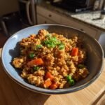 A close-up of a bowl filled with Irresistible Chicken Fried Rice With Vegetables, garnished with green onions.