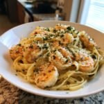A close-up of Irresistible Creamy Alfredo Shrimp Linguine in a white bowl, topped with chopped parsley and Parmesan cheese.
