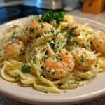 A close-up of Irresistible Creamy Alfredo Shrimp Linguine, featuring plump shrimp and fettuccine pasta coated in rich alfredo sauce, garnished with parsley.