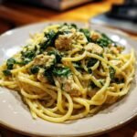 A close-up of Irresistible Creamy Spinach Chicken Pasta with tender chicken pieces and wilted spinach.