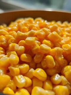 A close-up, macro shot of glistening kernels from an Irresistible Honey Butter Skillet Corn recipe.