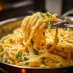 A fork lifting a swirl of Irresistible Smoked Cream Cheese Pasta, garnished with fresh parsley.
