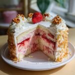 A slice of Irresistible Strawberry Crunch Cake, revealing layers of cake, strawberry filling, and cream.