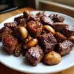 Close-up of perfectly seared Air Fryer Steak Bites With Mushrooms served on a white plate.