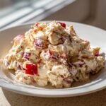Close-up of a serving of Apples Cheddar Chicken Salad with visible chunks of red apple and creamy dressing.