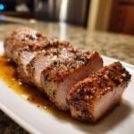 Close-up of sliced Instant Pot Garlic Pork Tenderloin, showing a juicy interior and seasoned, glazed crust.