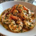 Close-up of plump shrimp coated in a rich, buttery sauce with visible parsley and garlic, showcasing the amazing Garlic Shrimp.