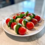 Close-up of Caprese skewers with cherry tomatoes, mozzarella balls, and basil, perfect for 4th of July appetizers.