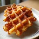 Close-up of two golden brown, crispy Easy Chaffles served on a light ceramic plate.