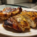 Close-up of juicy, grilled Lemongrass Grilled Chicken, sliced to show the white interior and caramelized exterior.