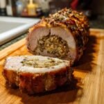 Cross-section view of a cooked Stuffed Pork Loin showing savory herb stuffing inside the rolled meat.