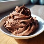 A swirl of rich, dark Chocolate Whipped Cream piped high in a small white bowl.