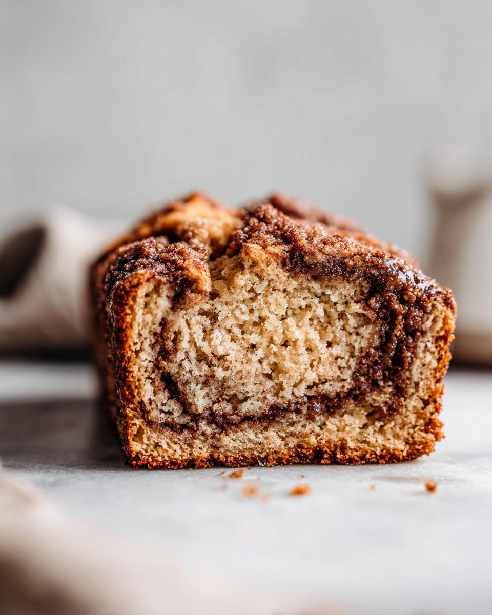 A close-up, low-angle view showing the moist interior and cinnamon swirl of the Cinnamon Swirl Quick Bread.