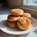A stack of soft, round Snickerdoodle Cake Mix Cookies coated in cinnamon sugar, resting on a white plate.