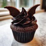 A rich chocolate cupcake topped with dark chocolate frosting and two chocolate bat wings, perfect for Bat Cupcakes.