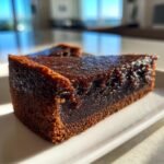 Close-up of a rich, dark slice of Fudge Dessert Pizza showing its dense, glossy top layer.