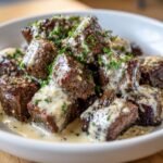Close-up of juicy Steak Bites With Parmesan Cream Sauce, garnished with fresh parsley.