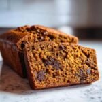 Close-up of a moist slice of Chocolate Pumpkin Bread showing rich orange color and dark chocolate chips.