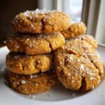 A close-up stack of soft, orange Pumpkin Pie Cookies generously topped with coarse sparkling sugar crystals.